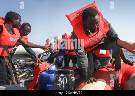 LAMPEDUSA, ITALY - MAY 19: A man is helped off a small rubber boat by crew members from NGO Sea-Eye on May 19, 2017 in international waters off the coast of Libya. (Photo by Christian Marquardt/NurPhoto) *** Please Use Credit from Credit Field *** Stock Photo