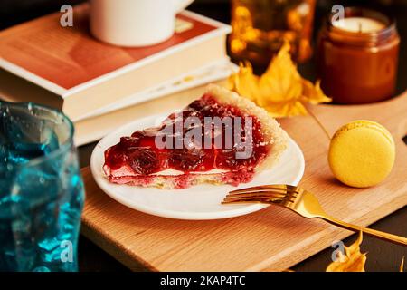 Cozy atmospheric home breakfast with cherry pie and macaroons. Seasonal autumn coffee time. Hygge home aesthetics. Stock Photo