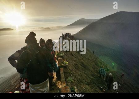 Tenggerese worshippers gather to give their offerings during the Yadnya Kasada Festival at crater of Mount Bromo in Probolinggo, East Java, Indonesia on July 10, 2017. Yadnya Kasada Festival is the main festival of the Tenggerese people and lasts about a month. On the fourteenth day, the Tenggerese make the journey to Mount Bromo to make offerings of rice, fruits, vegetables, flowers and livestock to the mountain gods by throwing them into the volcano's caldera. (Photo by Nugroho Hadi Santoso/NurPhoto) *** Please Use Credit from Credit Field *** Stock Photo