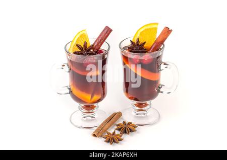 Traditional hot Christmas mulled wine with spices and oranges in mugs on a white background. Stock Photo