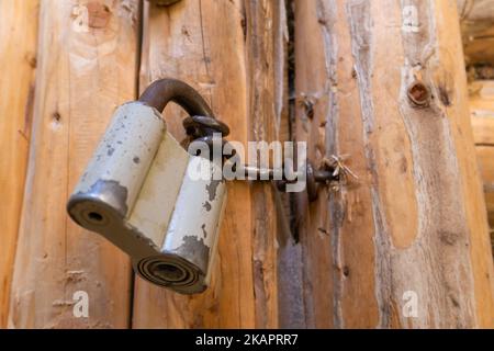 Close-up of a barn lock on wooden rustic doors of a log house. Stock Photo