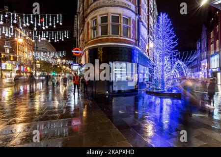 Christmas illuminations at the corner of oxford and south molten streets.Blue christmas displays reflected in the wet pavements.Xmas 2022 Stock Photo