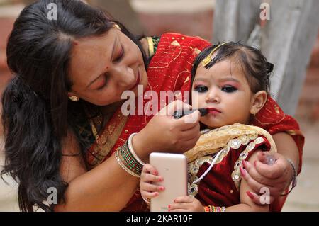 A Nepalese mother puts lipstick on her daughter's mouth during celebration of Kumari puja at Basantapur Durbar Square, Katmandu, Nepal on Monday, September 04, 2017. Altogether 108 young girls under the age of nine gathered for the Kumari puja, a tradition of worshiping, which believes doing puja save small girls from diseases and bad luck in future. (Photo by Narayan Maharjan/NurPhoto) Stock Photo