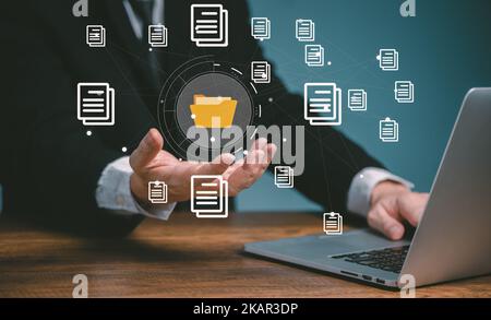 Document management system concept, business man using computer online holding folder and document icon software, searching and managing files online Stock Photo
