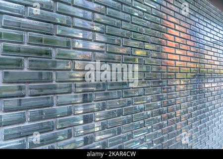 Austin, Texas- Reflective glass bricks wall exterior. Close-up of a building with glass wall with running bond bricks pattern and cement fillers. Stock Photo