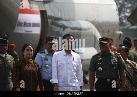 From L-R, front: Indonesia's Coordinating Minister for Human Development and Cultural Affairs Puan Maharani, Indonesia's President Joko Widodo, walk on the tarmac as Indonesian soldiers load sacks of government food aid onto an air force C-130 aircraft, bound for Bangladesh and its cargo destined for Rohingya refugees fleeing violence in Myanmar, at the Halim Perdanakusuma airport in Jakarta on September 13, 2017. UN's National Security Council plans to meet September 13 to discuss the Rohingya refugee crisis, which continues to deepen as the number of Rohingya refugees making it to Bangladesh Stock Photo