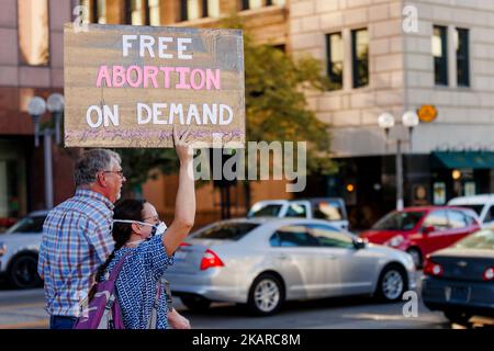 Abortion rights protesters stand by busy street holding a sign Stock Photo