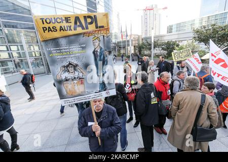 A man holds a sign reading ‘Don’t tuch to APL’during a demonstration against the reduction by €5 per month of the housing benefit in front of the Ministry of Territorial Cohesion in La Defense District business, near Paris, France on September 21, 2017. Housing benefits, known in France as APL (Aide personnalisée au logement), are also being cut. A government statement to the French television said that housing benefits for each claimant will be reduced by €5 per month from October 2017. Those affected by the cuts include 800,000 students, who receive around €225 a month, several of whom took  Stock Photo