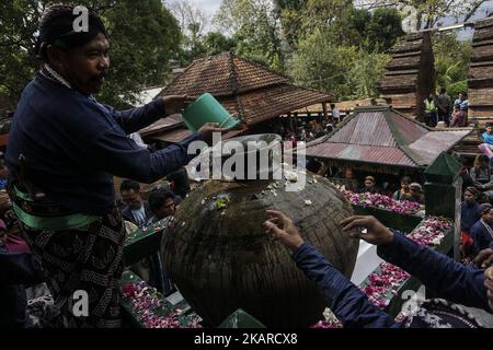 Javanese people follows the ritual of Nguras Enceh ceremony in the complex of the Tomb Kings Mataram at Yogyakarta, Indonesia, on September 22, 2017. Enceh drained a procession drain and fill the water back four enceh (big barrel) which is held every month of Muharram (Islamic calendar) or Suro (Javanese calendar) by the courtiers as known as abdi dalem of the Sultanate of Yogyakarta and Surakarta. Water from big barrel was then grabs by the pilgrims are believed to give a blessing and cure the disease. Nguras Enceh ceremony tradition has a meaning discard the bad things and replace them with  Stock Photo