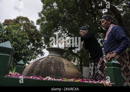 Javanese people follows the ritual of Nguras Enceh ceremony in the complex of the Tomb Kings Mataram at Yogyakarta, Indonesia, on September 22, 2017. Enceh drained a procession drain and fill the water back four enceh (big barrel) which is held every month of Muharram (Islamic calendar) or Suro (Javanese calendar) by the courtiers as known as abdi dalem of the Sultanate of Yogyakarta and Surakarta. Water from big barrel was then grabs by the pilgrims are believed to give a blessing and cure the disease. Nguras Enceh ceremony tradition has a meaning discard the bad things and replace them with  Stock Photo