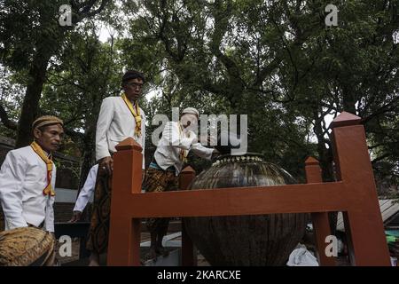 Javanese people follows the ritual of Nguras Enceh ceremony in the complex of the Tomb Kings Mataram at Yogyakarta, Indonesia, on September 22, 2017. Enceh drained a procession drain and fill the water back four enceh (big barrel) which is held every month of Muharram (Islamic calendar) or Suro (Javanese calendar) by the courtiers as known as abdi dalem of the Sultanate of Yogyakarta and Surakarta. Water from big barrel was then grabs by the pilgrims are believed to give a blessing and cure the disease. Nguras Enceh ceremony tradition has a meaning discard the bad things and replace them with  Stock Photo