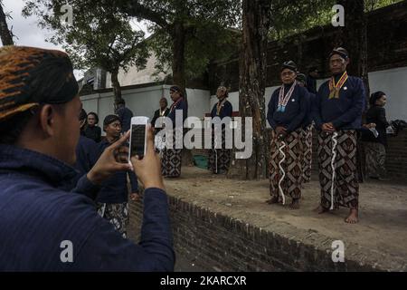 Javanese people follows the ritual of Nguras Enceh ceremony in the complex of the Tomb Kings Mataram at Yogyakarta, Indonesia, on September 22, 2017. Enceh drained a procession drain and fill the water back four enceh (big barrel) which is held every month of Muharram (Islamic calendar) or Suro (Javanese calendar) by the courtiers as known as abdi dalem of the Sultanate of Yogyakarta and Surakarta. Water from big barrel was then grabs by the pilgrims are believed to give a blessing and cure the disease. Nguras Enceh ceremony tradition has a meaning discard the bad things and replace them with  Stock Photo