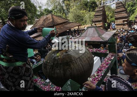 Javanese people follows the ritual of Nguras Enceh ceremony in the complex of the Tomb Kings Mataram at Yogyakarta, Indonesia, on September 22, 2017. Enceh drained a procession drain and fill the water back four enceh (big barrel) which is held every month of Muharram (Islamic calendar) or Suro (Javanese calendar) by the courtiers as known as abdi dalem of the Sultanate of Yogyakarta and Surakarta. Water from big barrel was then grabs by the pilgrims are believed to give a blessing and cure the disease. Nguras Enceh ceremony tradition has a meaning discard the bad things and replace them with  Stock Photo