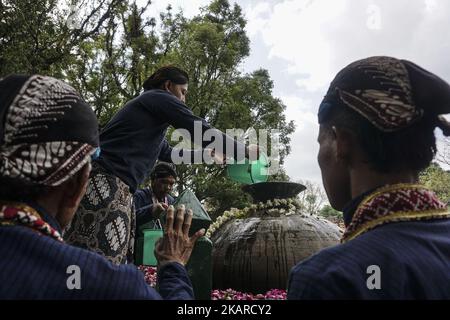 Javanese people follows the ritual of Nguras Enceh ceremony in the complex of the Tomb Kings Mataram at Yogyakarta, Indonesia, on September 22, 2017. Enceh drained a procession drain and fill the water back four enceh (big barrel) which is held every month of Muharram (Islamic calendar) or Suro (Javanese calendar) by the courtiers as known as abdi dalem of the Sultanate of Yogyakarta and Surakarta. Water from big barrel was then grabs by the pilgrims are believed to give a blessing and cure the disease. Nguras Enceh ceremony tradition has a meaning discard the bad things and replace them with  Stock Photo