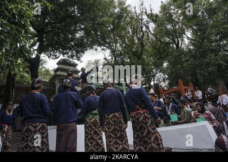 Javanese people follows the ritual of Nguras Enceh ceremony in the complex of the Tomb Kings Mataram at Yogyakarta, Indonesia, on September 22, 2017. Enceh drained a procession drain and fill the water back four enceh (big barrel) which is held every month of Muharram (Islamic calendar) or Suro (Javanese calendar) by the courtiers as known as abdi dalem of the Sultanate of Yogyakarta and Surakarta. Water from big barrel was then grabs by the pilgrims are believed to give a blessing and cure the disease. Nguras Enceh ceremony tradition has a meaning discard the bad things and replace them with  Stock Photo