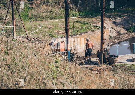 working fishermen work on shore of reservoir, high angle view Stock Photo