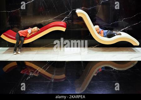 In airport transit hall little tired kids sleeping on lounge and waiting for boarding to airplane flight. Active family lifestyle, travel by air Stock Photo