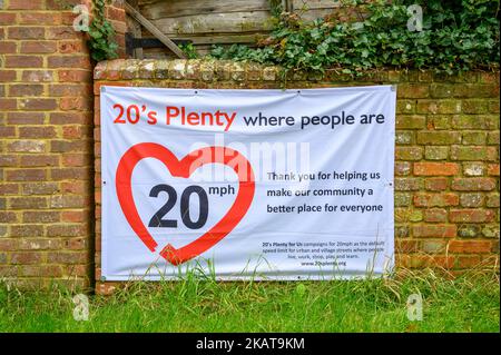 Local community banner with driving speed awareness campaign for 20 mph speed limit hanging on a brick wall in Shipley village, West Sussex, England. Stock Photo