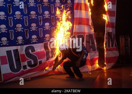 Protesters burn a mock US flag as they marched in protest against the 31st ASEAN Summit and Related Meetings in Manila on 13 November 2017. Various protests were held by different militant groups throughout the day to air their grievances against the government. (Photo by George Calvelo/NurPhoto) Stock Photo