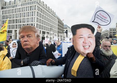 Protesters wearing the masks of US President Donald Trump and North Korean dictator Kim Jong-un attend a demonstration organized from awarded Nobel Peace Prize 2017 ICAN (International Campaign to Abolish Nuclear Weapons) in front of Brandenburg Gate in Berlin on November 18, 2017. The associations protest against nuclear weapons and escalation of tenstions between US and North Korea. (Photo by Emmanuele Contini/NurPhoto) Stock Photo