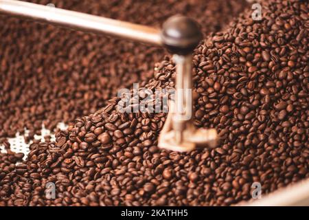 Roasting coffee beans in a professional old coffee roasting machine or roaster, close up Stock Photo