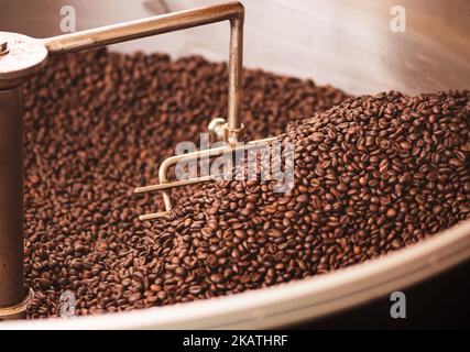 Roasting coffee beans in a professional old coffee roasting machine or roaster, close up Stock Photo