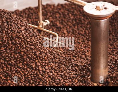 Roasting coffee beans in a professional old coffee roasting machine or roaster, close up Stock Photo