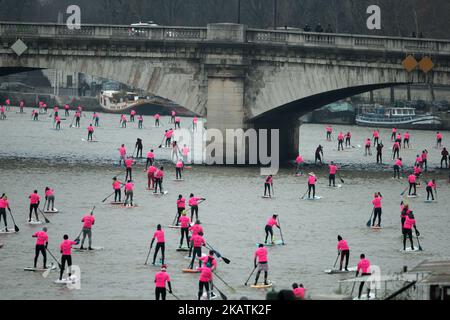 Paddle boarders pass near the Pont Royal bridge as they participate in the morning light in the Nautic SUP Paris crossing on the river Seine on December 3, 2017 in Paris. The Nautic SUP Paris crossing is the biggest Stand Up Paddle race in the world, offering the unique opportunity of paddling down the River Seine past the Eiffel Tower and other iconic landmarks. (Photo by Michel Stoupak/NurPhoto) Stock Photo
