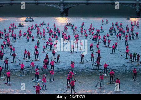 Paddle boarders pass near the Pont de Bercy bridge as they participate in the morning light in the Nautic SUP Paris crossing on the river Seine on December 3, 2017 in Paris. The Nautic SUP Paris crossing is the biggest Stand Up Paddle race in the world, offering the unique opportunity of paddling down the River Seine past the Eiffel Tower and other iconic landmarks. (Photo by Michel Stoupak/NurPhoto) Stock Photo