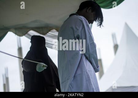 An Acehnese man is whipped in front of the public for violating sharia law  at Islamic Center Mosque Lhokseumawe, in Aceh Province, Indonesia on  October 25, 2017. Aceh is the only province