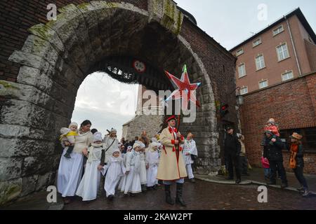 Young performers dressed as angels follow a man carrying the star during the annual 'Orszak Trzech Kroli' (English: the Three Kings procession) in Krakow, Poland on January 6, 2018. The procession, which annually marks the end of the Christmas festivities is a re-enactment of the journey of the Three Wise Men to visit the infant Jesus. (Photo by Artur Widak/NurPhoto)  Stock Photo