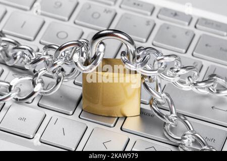 Locked chain on laptop computer keyboard. Cyber safety Stock Photo