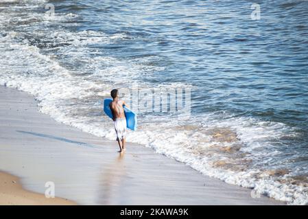 Salvador, Bahia, Brazil - November 01, 2021: Surfer entering the water of Rio Vermelho beach in Salvador, Bahia. Stock Photo