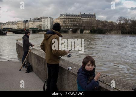 People with their fishing poles taking advantage of the river Seine's level in Paris, on January 26, 2018 The wettest January in almost 100 years. The level of the Seine river has already reach 6 meters (19.6 ft) and it forecast to keep increasing. The Louvre and Orsay museum have been closed so staff can move invaluable artwork to safety. A few metro stations where also closed. (Photo by David Cordova/NurPhoto) Stock Photo