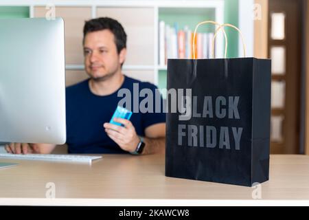 Man in his home office buying things online for black friday Stock Photo