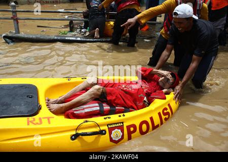 The joint rescue officers from the fire department, police and Jakarta Regional Disaster Mitigation Agency, evacuated residents as floods hit several areas in Jakarta on Tuesday, February 6, 2018. Heavy rains that occurred over the past few days, caused a number of areas in the capital flooded with high altitude water ranges from 50-200 cm. (Photo by Aditya Irawan/NurPhoto) Stock Photo