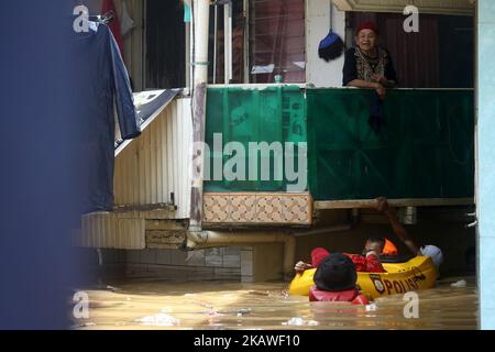 The joint rescue officers from the fire department, police and Jakarta Regional Disaster Mitigation Agency, evacuated residents as floods hit several areas in Jakarta on Tuesday, February 6, 2018. Heavy rains that occurred over the past few days, caused a number of areas in the capital flooded with high altitude water ranges from 50-200 cm. (Photo by Aditya Irawan/NurPhoto) Stock Photo