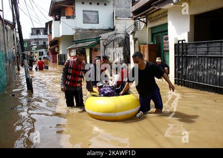 The joint rescue officers from the fire department, police and Jakarta Regional Disaster Mitigation Agency, evacuated residents as floods hit several areas in Jakarta on Tuesday, February 6, 2018. Heavy rains that occurred over the past few days, caused a number of areas in the capital flooded with high altitude water ranges from 50-200 cm. (Photo by Aditya Irawan/NurPhoto) Stock Photo