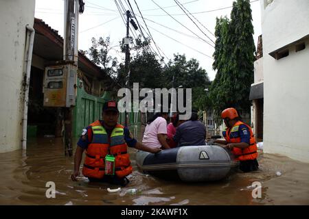 The joint rescue officers from the fire department, police and Jakarta Regional Disaster Mitigation Agency, evacuated residents as floods hit several areas in Jakarta on Tuesday, February 6, 2018. Heavy rains that occurred over the past few days, caused a number of areas in the capital flooded with high altitude water ranges from 50-200 cm. (Photo by Aditya Irawan/NurPhoto) Stock Photo