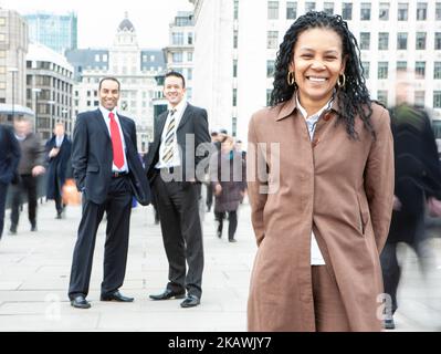 London Professionals, Business Woman. A mature black businesswoman leading her diverse team on the City streets. From a series of related images. Stock Photo