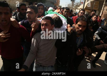 (EDITORS NOTE: Image contains graphic content) Mourners carry the body of Palestinian Ahmad Abu Al-Helo, 19, during his funeral in Al Bureij refugee camp in the central Gaza strip February 21, 2018. (Photo by Majdi Fathi/NurPhoto) Stock Photo