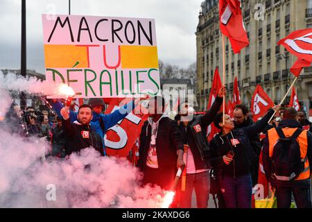 Protesters hold up a banner and ignited flares during a protest by railway workers and other labor union members outside Gare de l'Est railway station in Paris, France, on Tuesday April 3, 2018. Trains and planes were canceled across France as unions pushed forward with protests against President Emmanuel Macrons plans to strip benefits from some state workers. (Photo by Julien Mattia/NurPhoto) Stock Photo