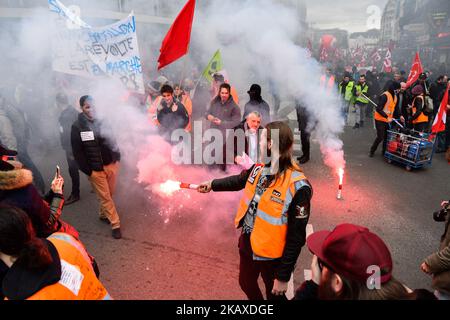 Protesters hold up a banner and ignited flares during a protest by railway workers and other labor union members outside Gare de l'Est railway station in Paris, France, on Tuesday April 3, 2018. Trains and planes were canceled across France as unions pushed forward with protests against President Emmanuel Macrons plans to strip benefits from some state workers. (Photo by Julien Mattia/NurPhoto) Stock Photo