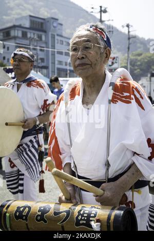 A man plays a percussion during a Japanese traditional dance called 'Odori' during the Ose Matsuri/festival held at Uchiura fishing port in the Osezaki district of Numazu, Shizuoka Prefecture in Japan on April 4, 2018. The festive boats, decorated with colorful flags paraded the port after heading to a nearby Ose Jinja shrine, where the fishermen offered prayers for a big catch and safe sailing. The fishermen traditionally dress up as women during the festival to ensure safe trips to sea and good catches. The custom is said originated from a local folklore when the wife of a fisherman gave her Stock Photo