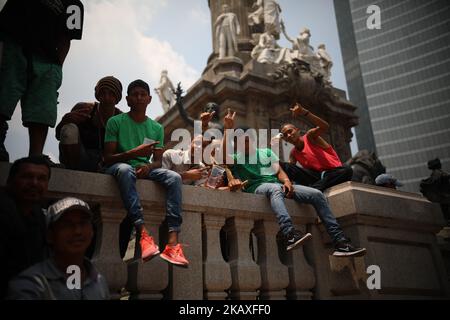 A group of Central Americans, part of the annual Stations of the Cross caravan march for migrants' rights, sit on the steps of the Angel of Independence monument during a protest in Mexico City, Saturday, April 7, 2018. Mexico's capital is the final planned stop of the migrant caravan that left from the Mexico-Guatemala border late last month to draw attention to policies toward immigrants and refugees. (Photo by Emilio Espejel/NurPhoto) Stock Photo