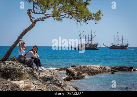 Tourists take a selfie on a rock outcrop on the Mediterranean Sea in Phaselis, Antalya, a historic tourism attraction in southern Turkey on 22 April 2018. (Photo by Diego Cupolo/NurPhoto) Stock Photo