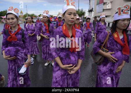 Thai workers wear costumes to resemble pregnant women as they march in Bangkok, Thailand, 01 May 2018. (Photo by Anusak Laowilas/NurPhoto) Stock Photo