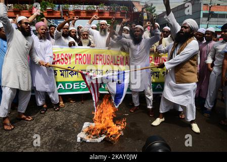 Activists from an Islamic organization burn the US and Israel national flags as they shout anti US and Israel slogans during a protest after Friday prayers on the first Friday of the holy month of Ramadan in front of National mosque in Dhaka, Bangladesh, on May 18, 2018. Israel has come under mounting international pressure after its forces opened fire on the Gaza border on May 14, killing 60 protesters who had massed alongside the fence to protest as the US moved its embassy from Tel Aviv to Jerusalem. (Photo by Mamunur Rashid/NurPhoto)Activists from an Islamic organization burn the US and Is Stock Photo