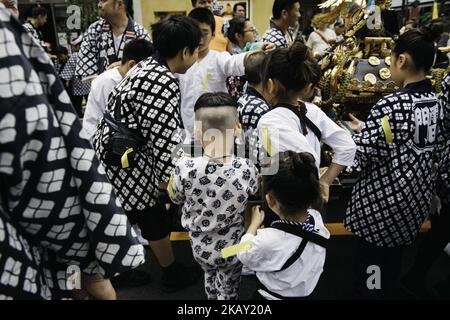 Japanese children wearing 'happi' coats relax during break time just after carrying the portable shrine in Tokyo's one of the largest three day festival called 'Sanja Matsuri' on it's second day, May 19, 2018 in Tokyo, Japan. A boisterous traditional mikoshi (portable shrine) is carried in the streets of Asakusa to bring luck, blessings and prosperity to the area and its inhabitants. (Photo: Richard Atrero de Guzman/Nur Photo) (Photo by Richard Atrero de Guzman/NurPhoto) Stock Photo