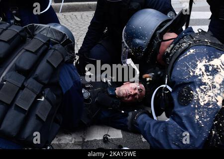 Riot police officers take care of an injured colleague during clashes as demonstrators take part in a 'maree populaire' (working-class tide) demonstration called by political organizations, associations and unions to protest against French President and government's policy, in Paris on May 26, 2018. (Photo by Julien Mattia/NurPhoto) Stock Photo